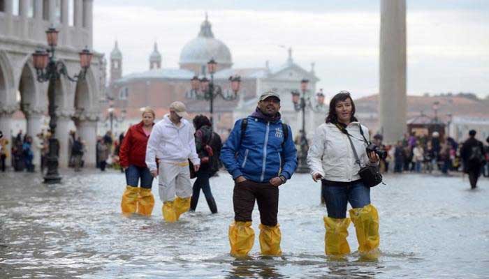 لتحدي الفيضانات.. "أحذية بأعناق طويلة" حيلة مطاعم فينيسيا (مع فيديو)