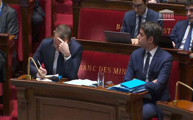 وزير العمل الفرنسي أوليفييه دوسوبت ينهمك بحل الكلمات المتقاطعة خلال نقاش بالبرلمان